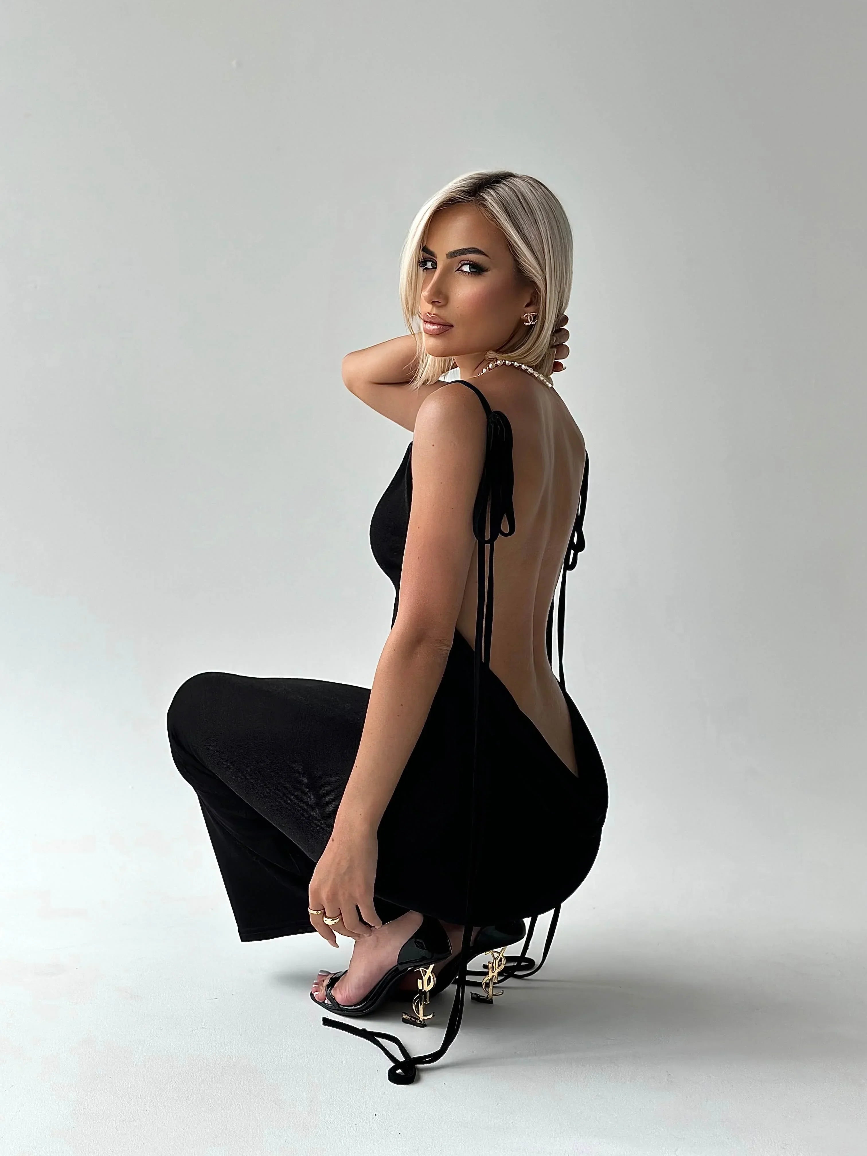 Black women's backless maxi dress featuring adjustable ties, crafted from soft, breathable fabric for a comfortable fit.