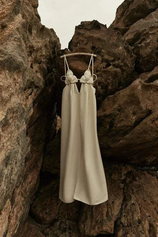 Women’s beige maxi dress with floral accents, a front slit, and lightweight fabric, perfect for warm weather outings.