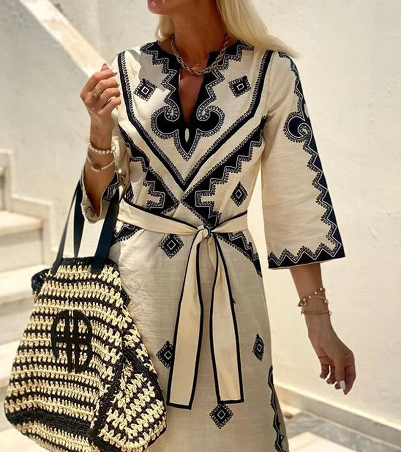 Beige midi dress featuring geometric prints, a woven belt, and lightweight fabric, perfect for casual or semi-formal…