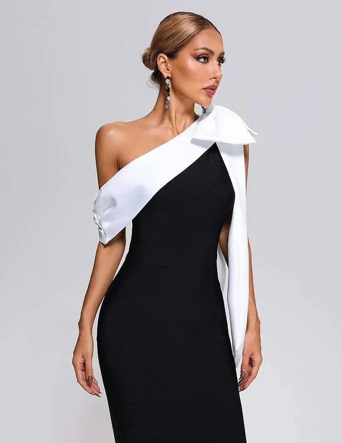 Women’s black and white one-shoulder midi dress featuring a bow accent and lightweight fabric for a timeless silhouette.