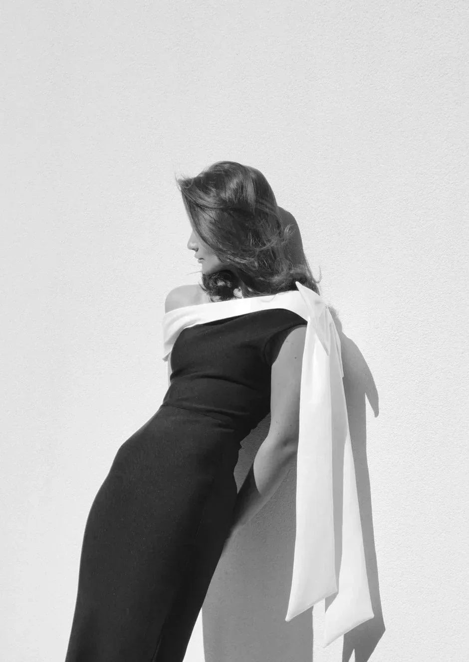 Women's one-shoulder midi dress in black and white, featuring a bow accent and made from soft, lightweight fabric.