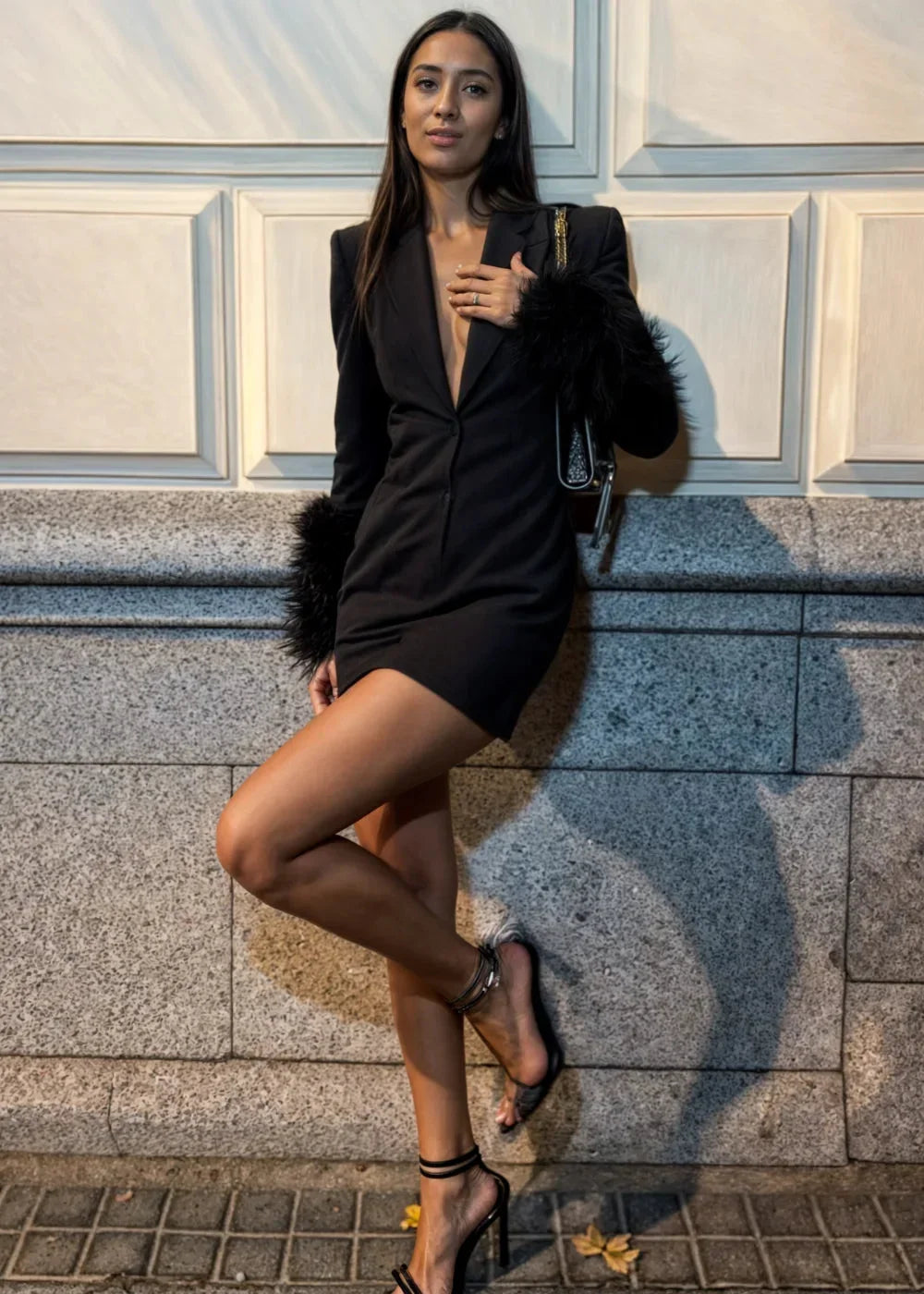 Women’s black mini dress featuring textured faux fur sleeves, a fitted bodice, and a sleek silhouette for a modern look.