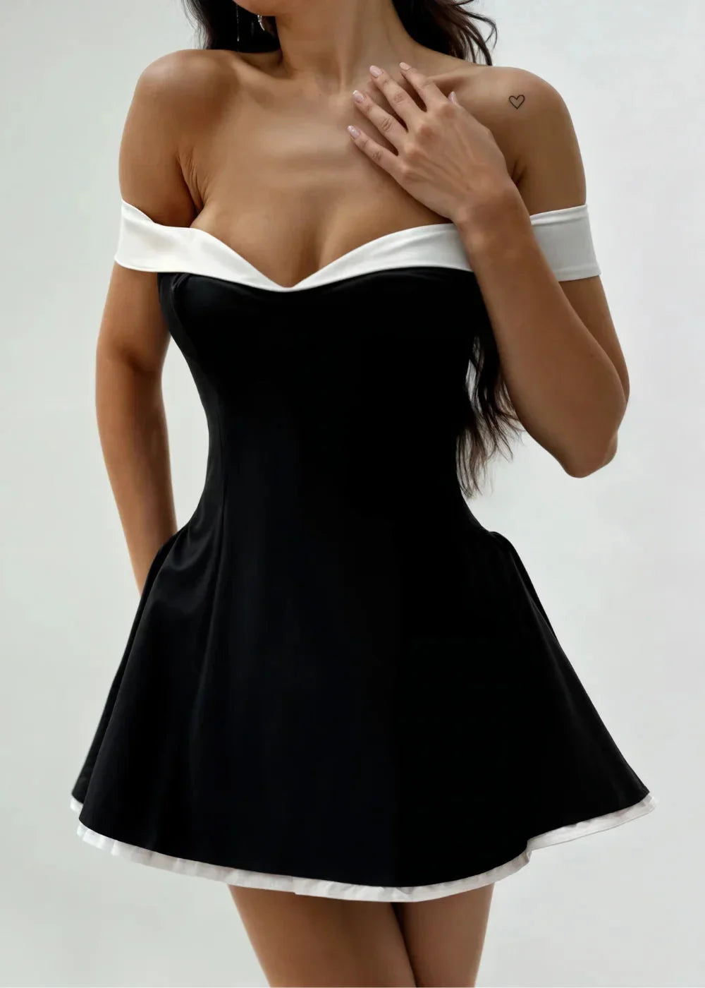 Women’s black off-shoulder mini dress made of lightweight fabric, featuring white trim and a flared skirt design.