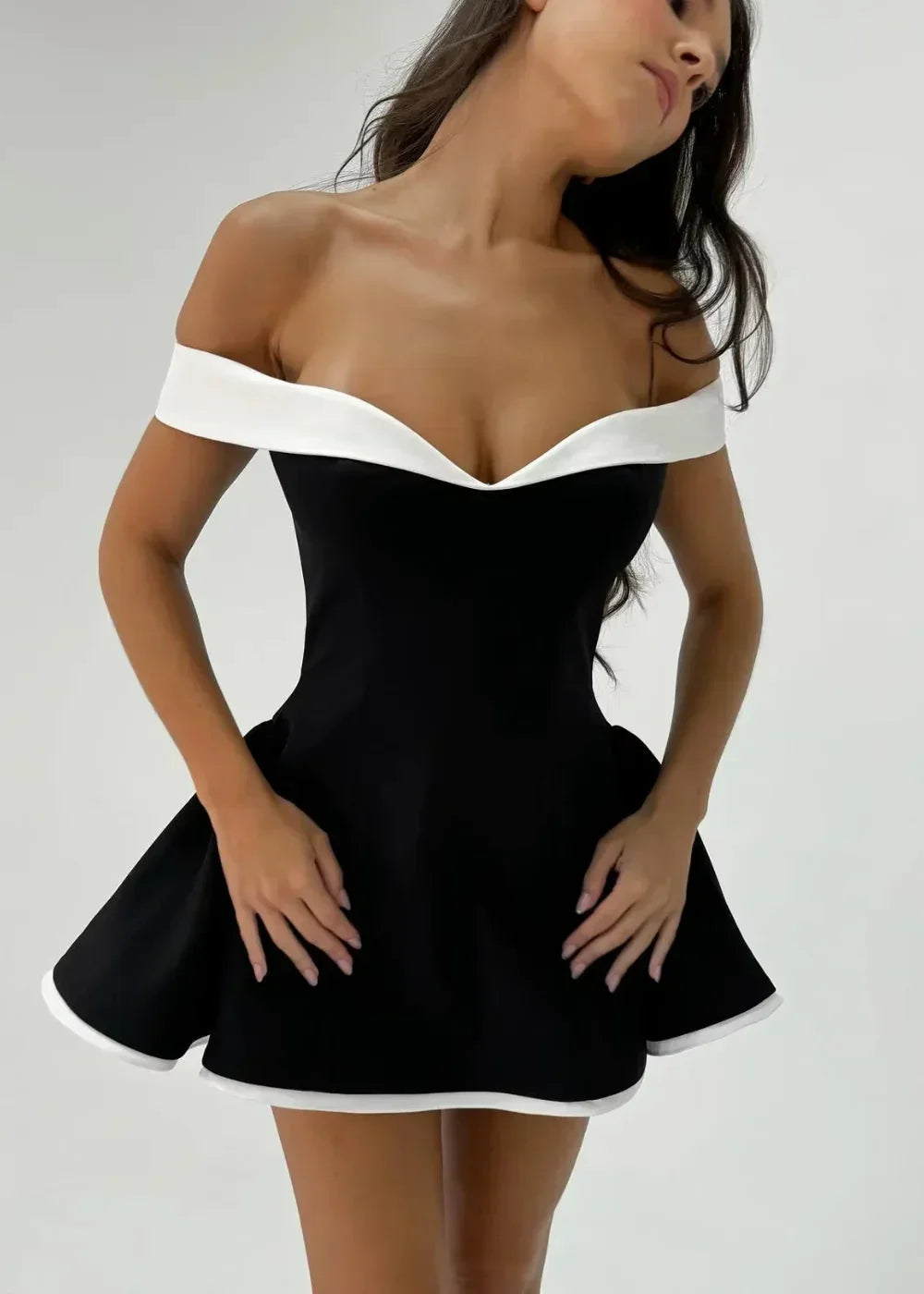 Women’s black off-shoulder mini dress featuring white trim, flared skirt, and lightweight fabric for comfort and style.