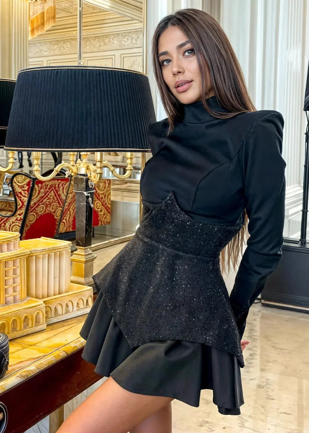 Women’s black sequin peplum mini dress with long sleeves, featuring a fitted bodice and flared hem for a stylish silhouette.