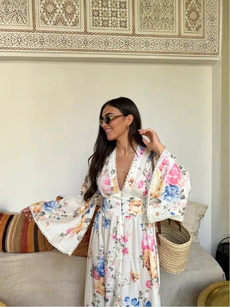 White long-sleeve boho floral maxi dress made from lightweight fabric with a flowy design and delicate floral patterns.