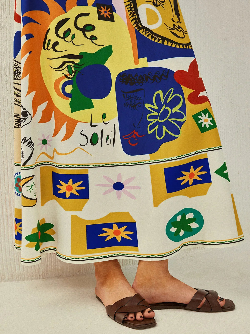 Women's colorful printed midi dress with cami straps, made from lightweight fabric featuring a vibrant floral design.