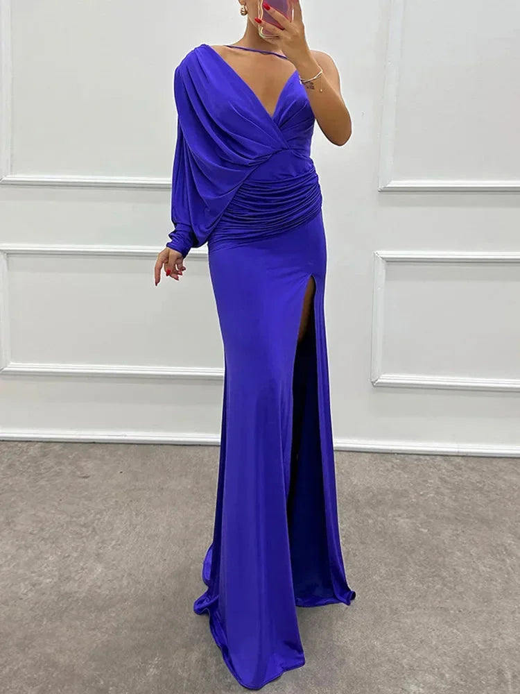 Blue one-shoulder maxi dress features a draped design and side slit, crafted from soft lightweight fabric for comfort.