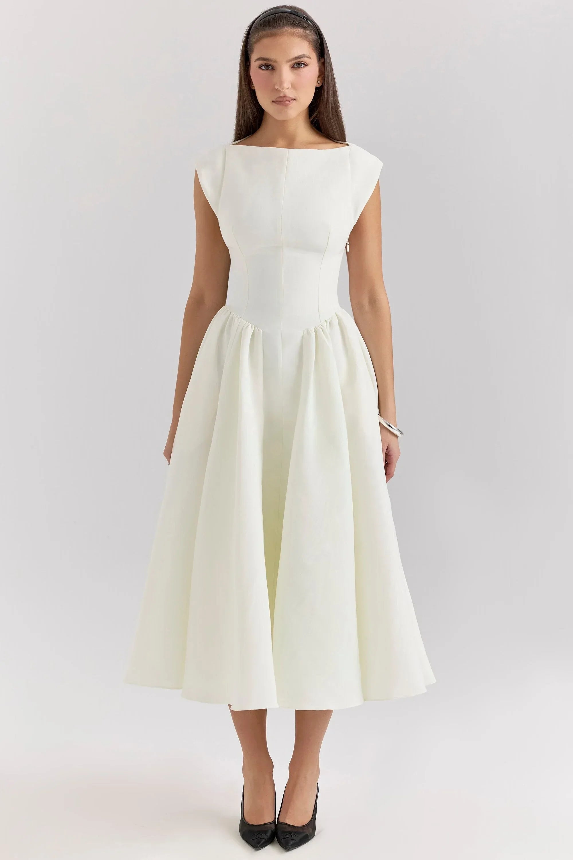 White midi dress with sculpted bodice and cap sleeves, crafted from soft, breathable fabric for comfort and elegance.