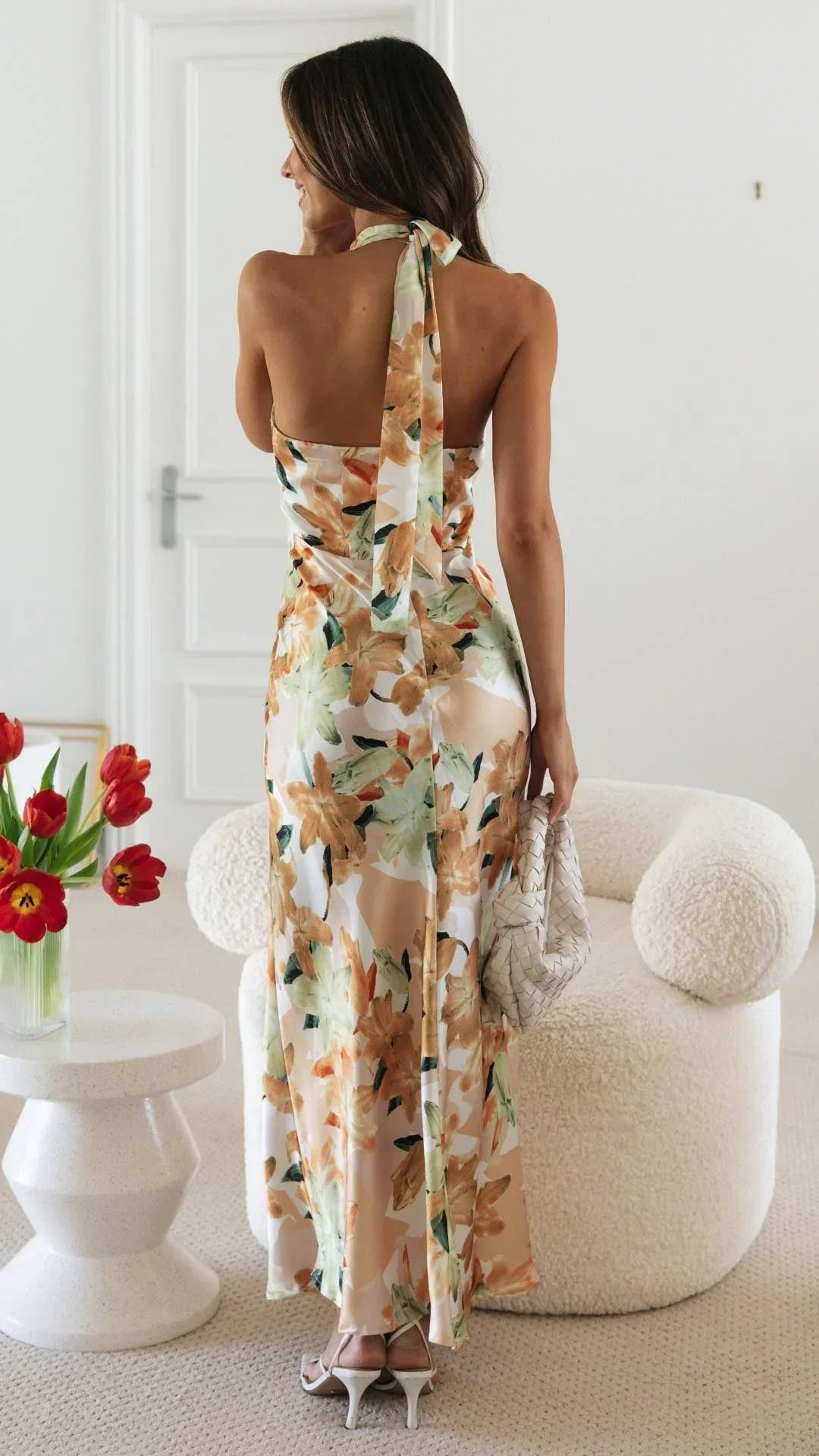 Women’s floral maxi dress featuring a halter neckline, made from lightweight fabric with a flowy silhouette and vibrant…