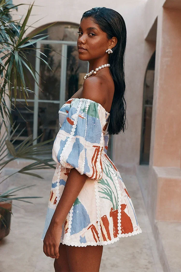 Women’s floral off-shoulder mini dress in lightweight fabric, featuring puff sleeves and a playful floral pattern.