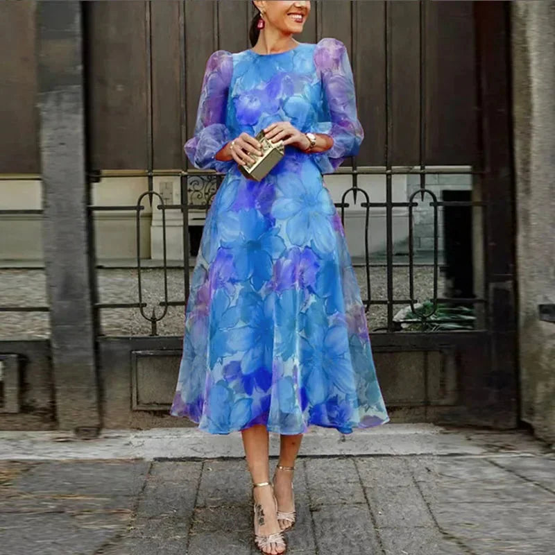 Blue floral print midi dress featuring sheer puff sleeves and a lightweight fabric, perfect for casual outings or special…