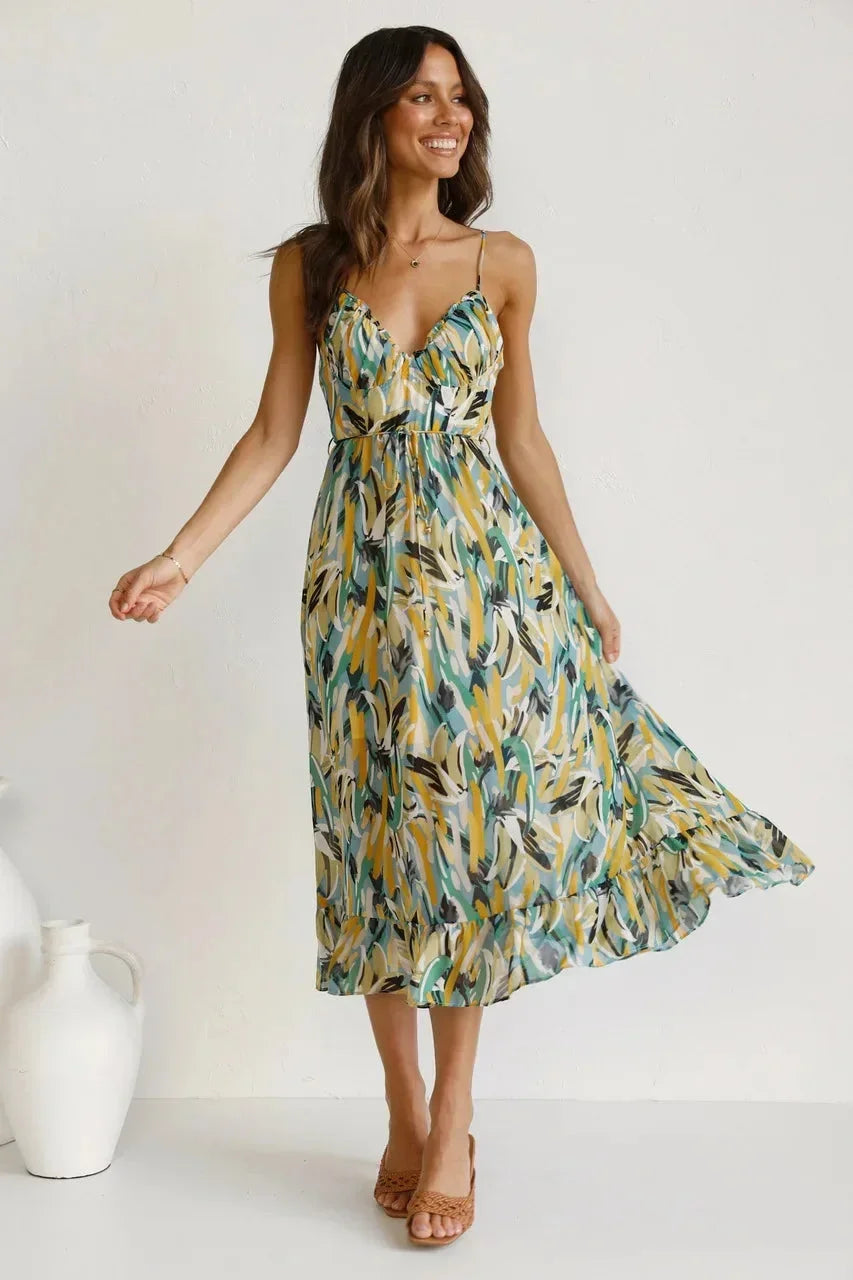 Green women's flowy maxi dress with spaghetti straps and an abstract print, made from lightweight, breathable fabric.
