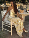 Women’s gold satin maxi dress featuring foil details and adjustable straps for a stylish silhouette, perfect for evening…