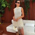 Ivory sleeveless mini dress featuring tassel accents, made from lightweight fabric, perfect for warm-weather outings.