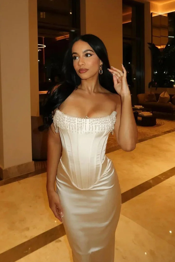 Ivory strapless midi dress with beaded corset design, featuring fitted bodice and flowing skirt for a chic look.