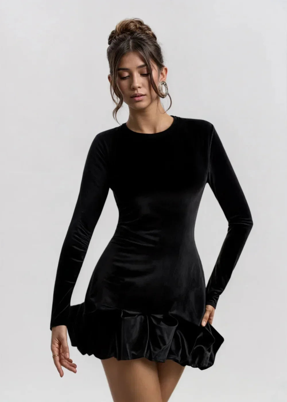 Black women’s long-sleeve velvet mini dress features a ruffle hem and soft texture, perfect for casual or dressy occasions.