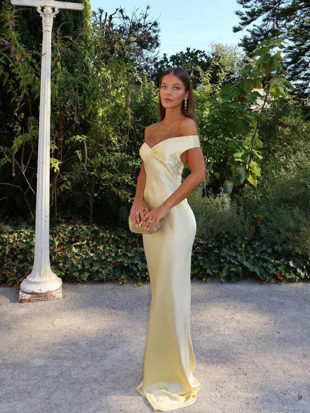 Women’s off-shoulder yellow maxi dress in lightweight fabric, featuring a flowy design and comes with a matching clutch.