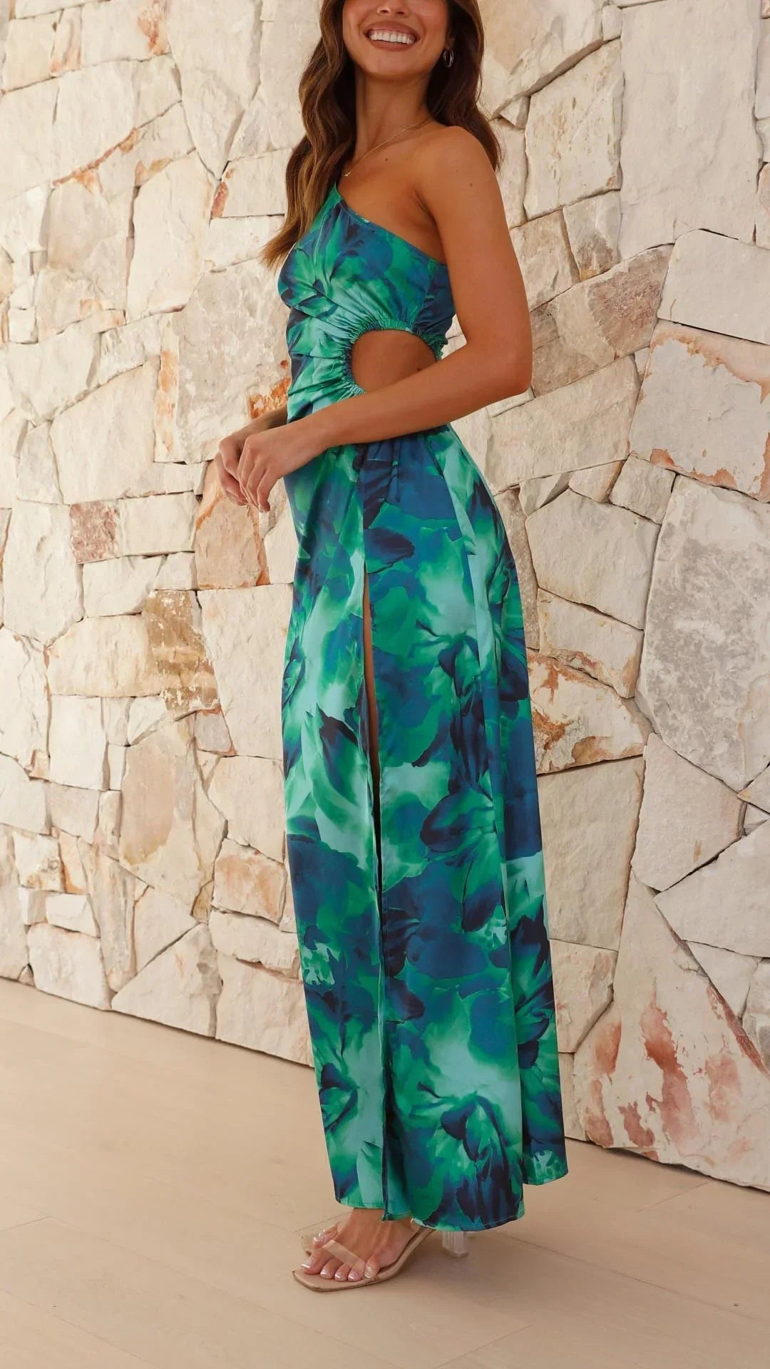 Women’s one-shoulder green floral maxi dress made of lightweight fabric, featuring a side slit and a vibrant floral print.
