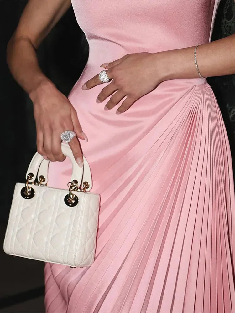 Women’s pink pleated sleeveless maxi dress with asymmetrical neckline, crafted from soft, lightweight fabric for comfort and…