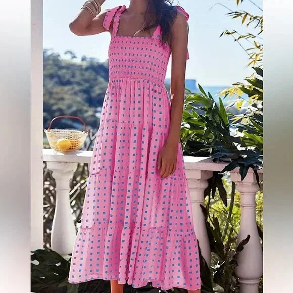 Women’s pink smocked maxi dress featuring tie straps and blue accents, made from soft cotton for comfort and breathability.