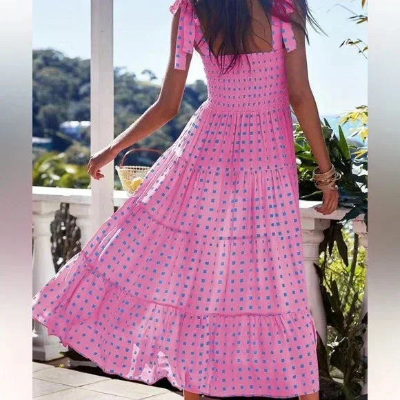 Women’s pink smocked maxi dress featuring tie straps, blue accents, and breathable cotton fabric for a comfortable fit.