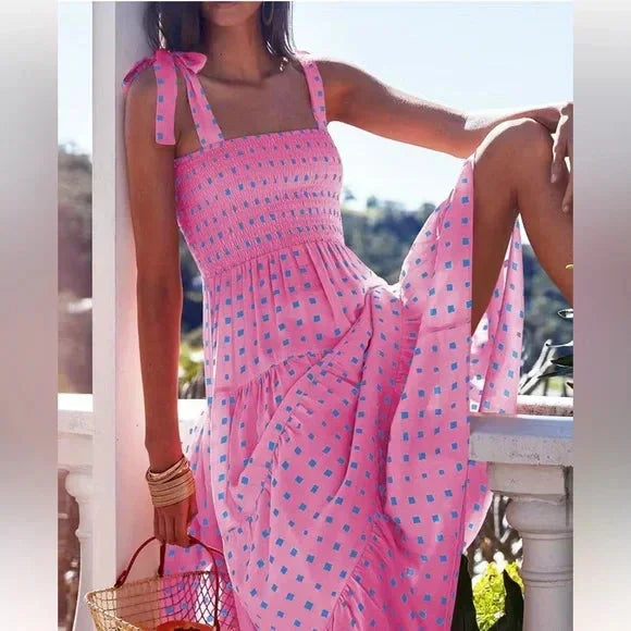 Women’s pink smocked maxi dress with tie straps, featuring blue accents and lightweight fabric, perfect for warm weather.