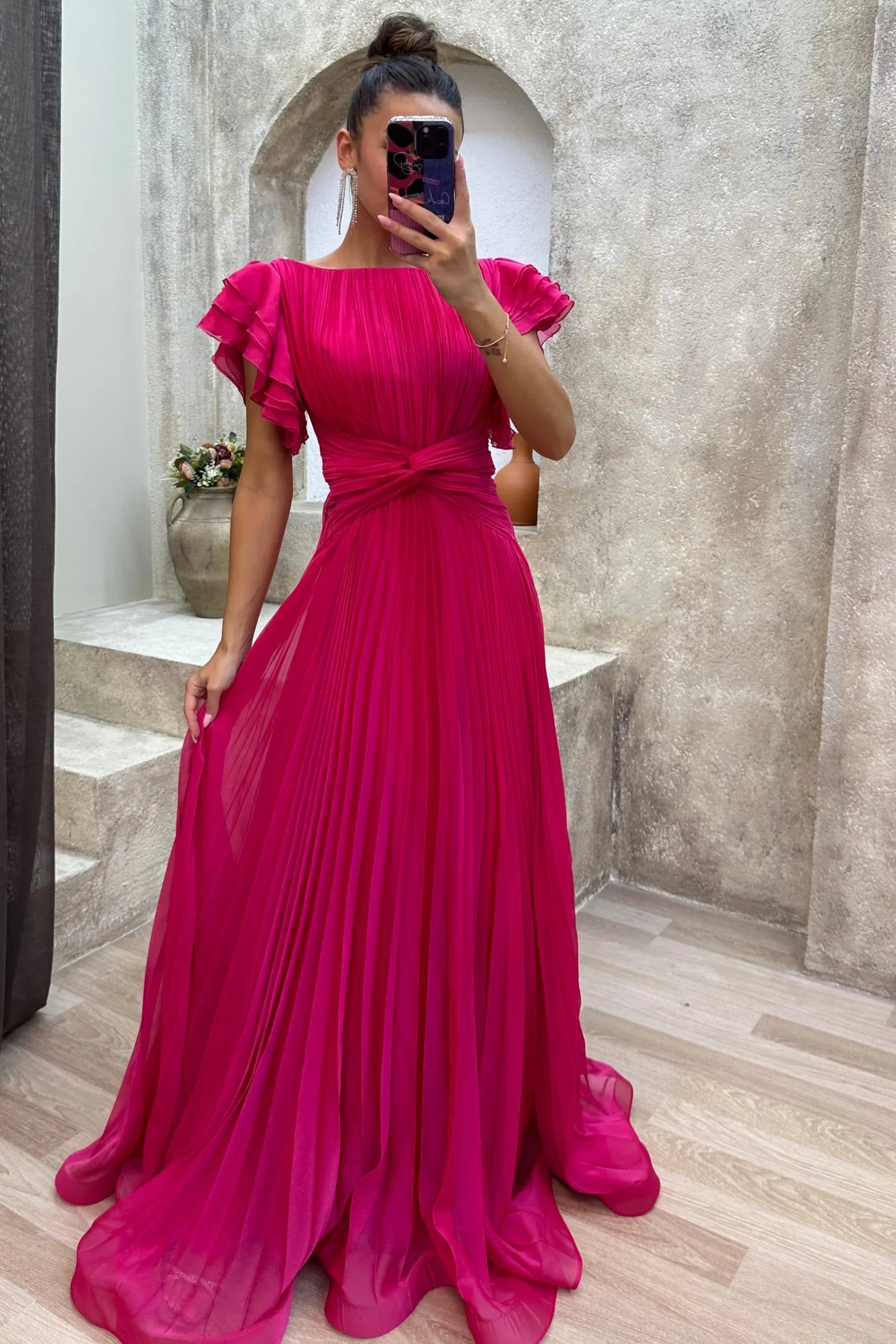Pink women’s pleated maxi dress featuring ruffled sleeves and a unique tie detail, crafted from lightweight, breathable…