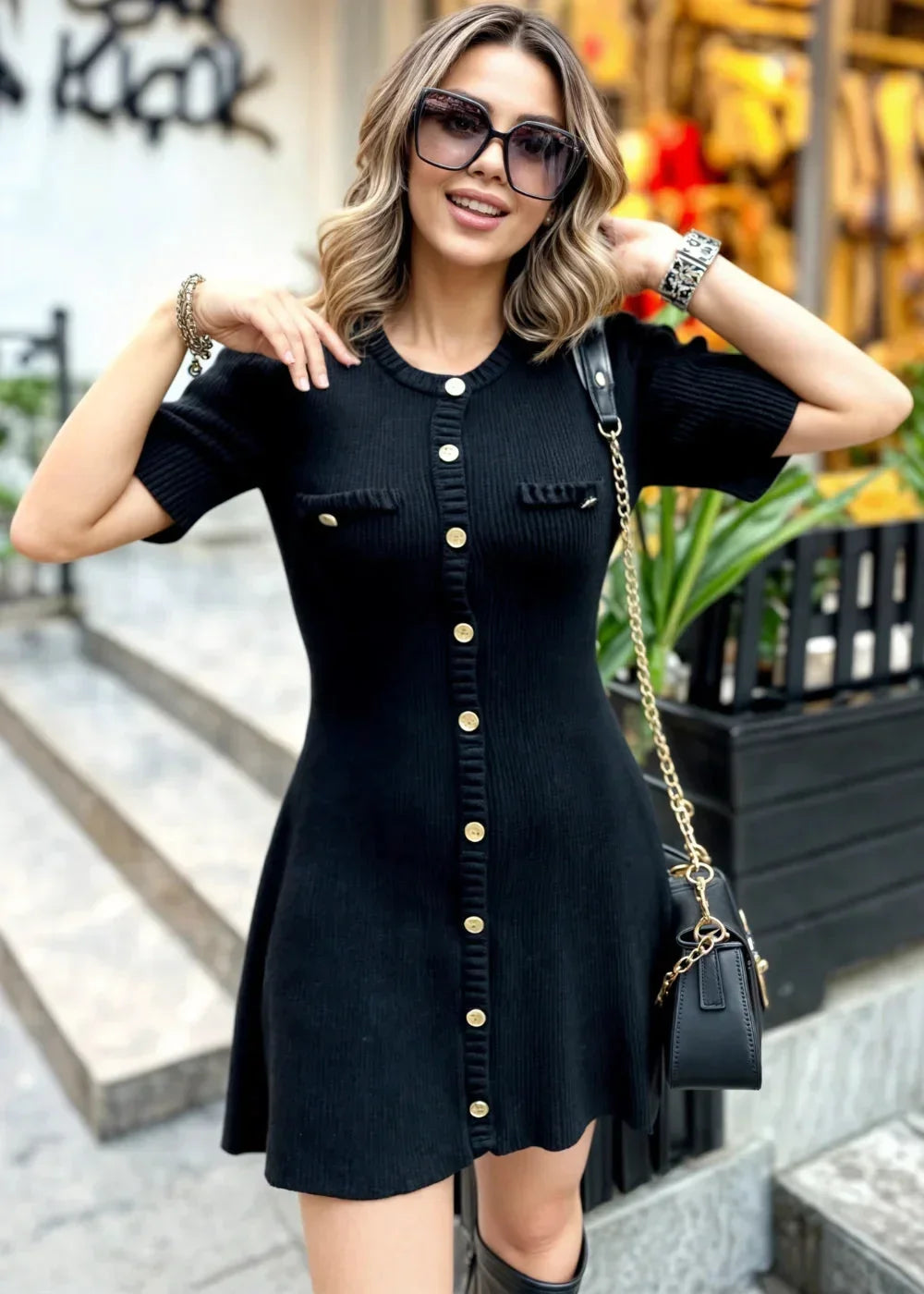 Black women's ribbed knit mini dress featuring button details and a fitted silhouette for a comfortable and stylish look.