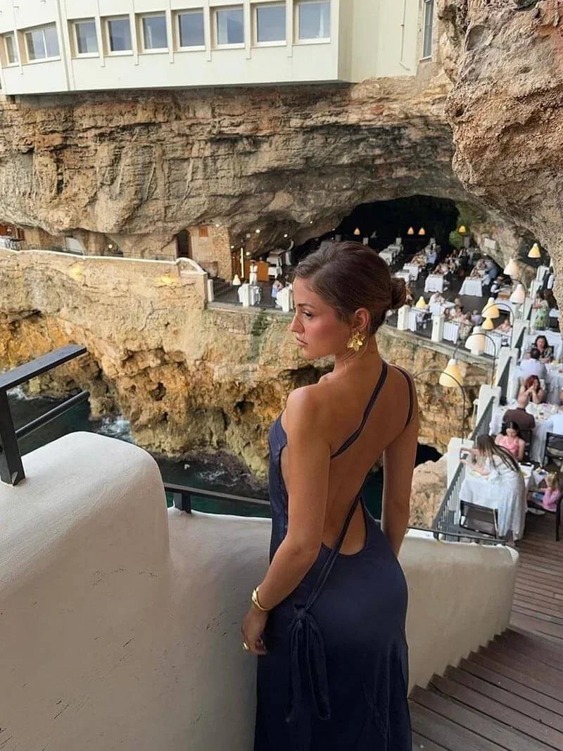 Backless women’s maxi dress in satin with spaghetti straps, featuring a flowing design perfect for warm weather occasions.