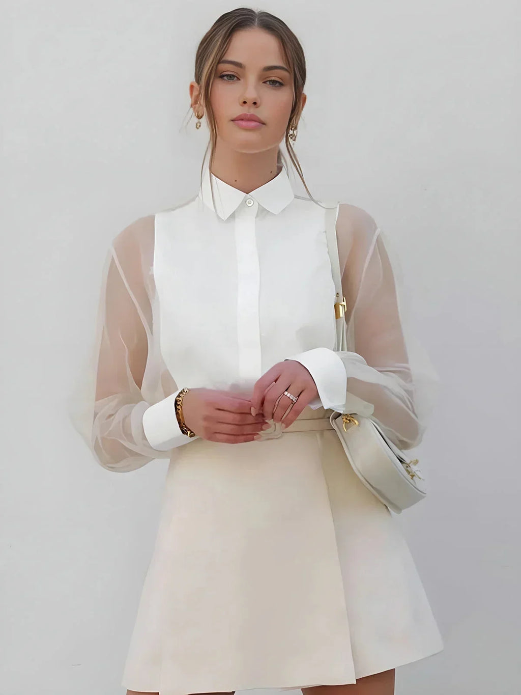 White sheer long sleeve mini dress with a collared neckline, featuring lightweight fabric and a flared silhouette.