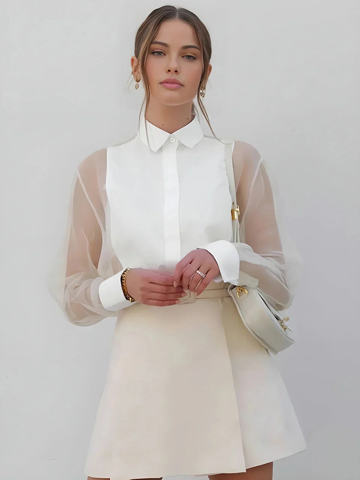 White sheer long sleeve mini dress with a collared neckline, featuring lightweight fabric and a flared silhouette.