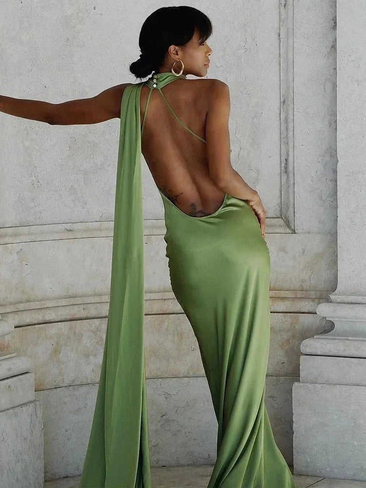 Women’s satin floor-length cape dress with a halter neck, featuring a smooth finish and elegant flowing design.