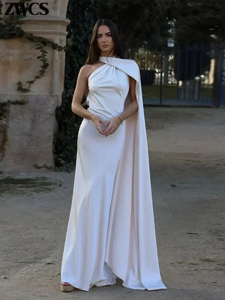Women’s satin floor-length cape dress with a halter neck, featuring a flowing design and smooth, shiny fabric.