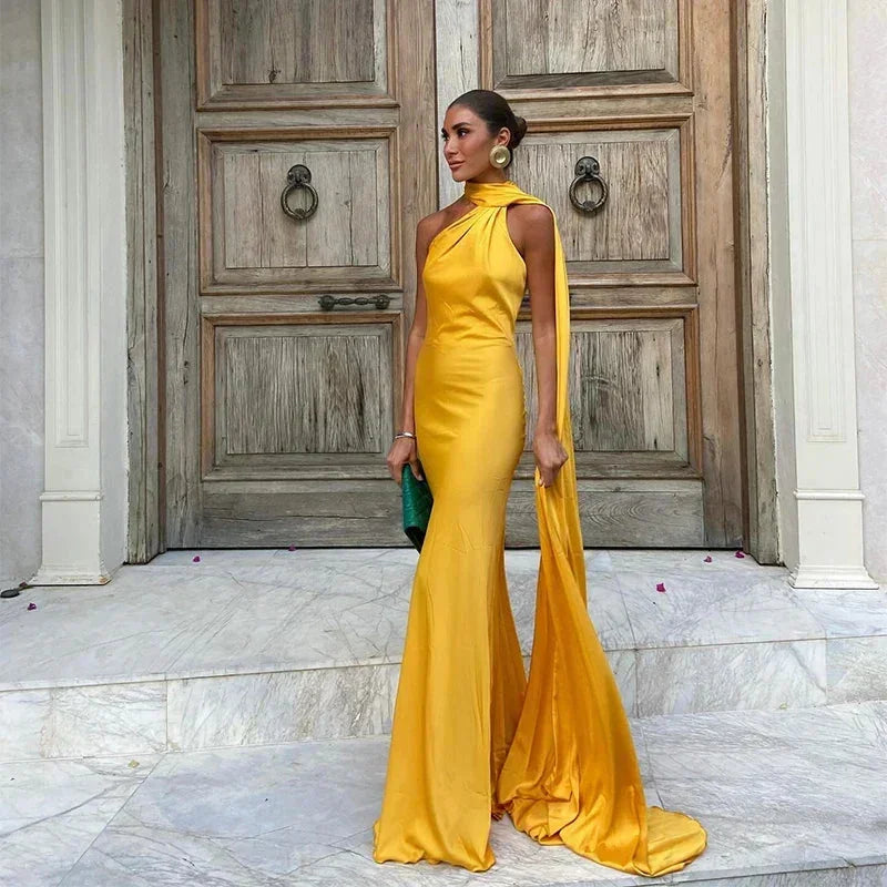 Women’s yellow satin cape dress, floor-length with a halter neck design, featuring a smooth, flowing silhouette.