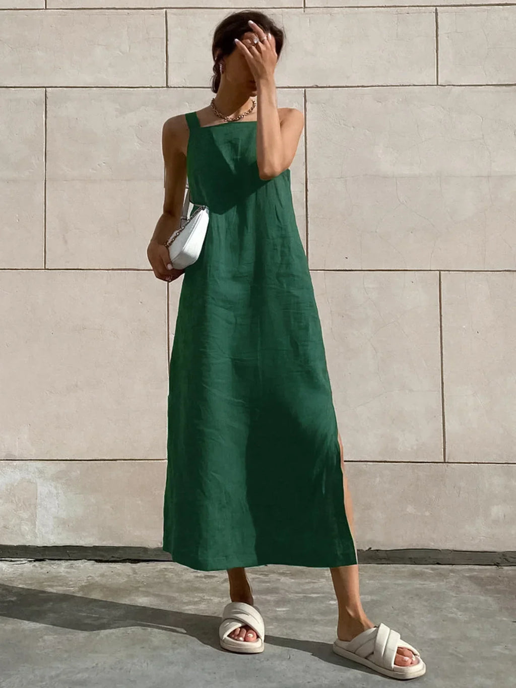 Green sleeveless A-line midi dress with side slit, made from breathable fabric, showcasing a comfortable and stylish…
