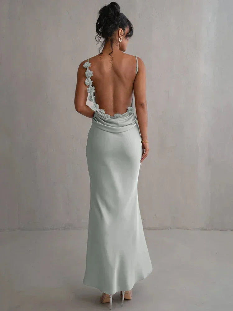 Women's sleeveless backless maxi dress in lightweight fabric, featuring intricate floral details and a flowing silhouette.