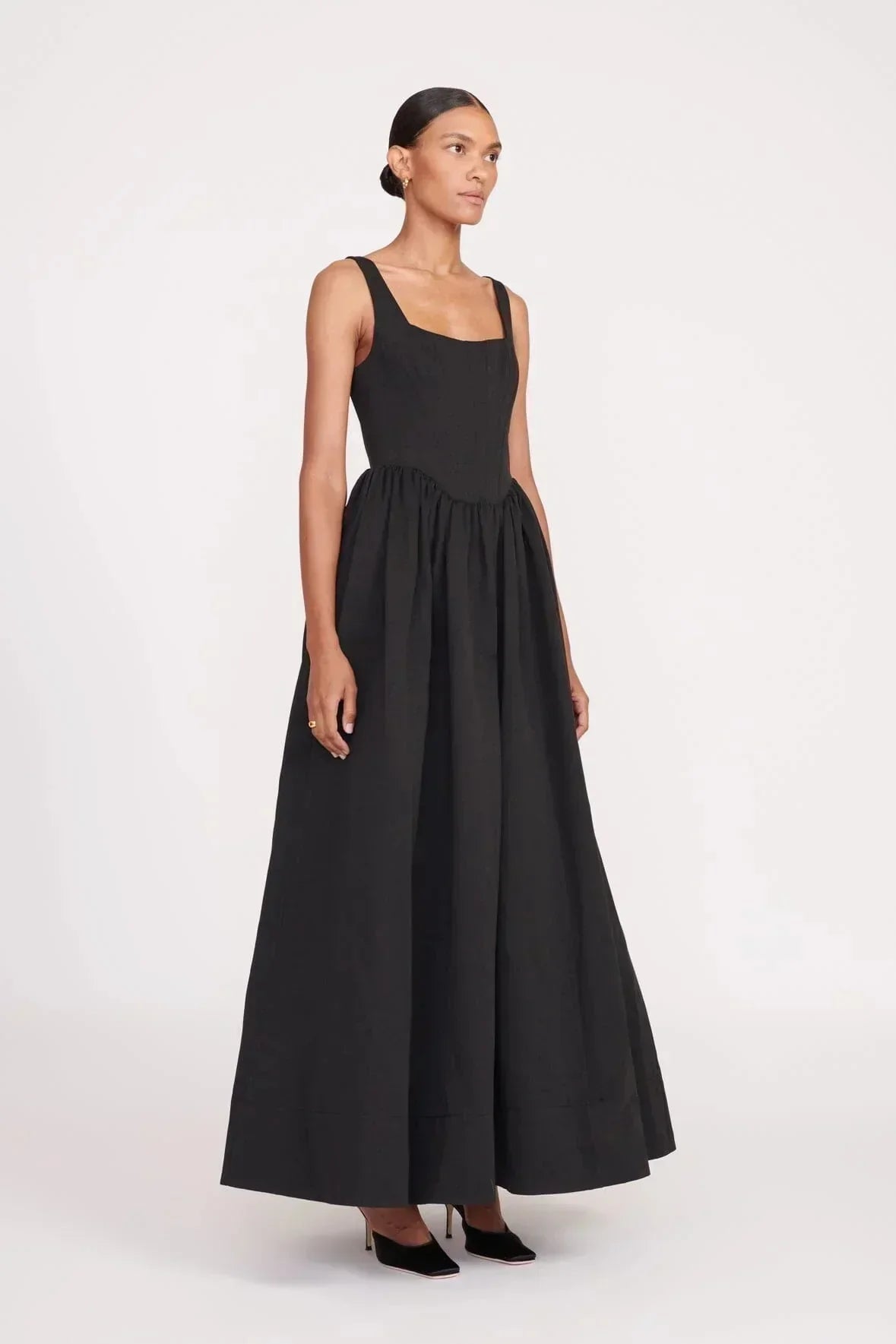 Women's sleeveless black maxi dress with square neckline, flared skirt design, made from lightweight cotton blend fabric.