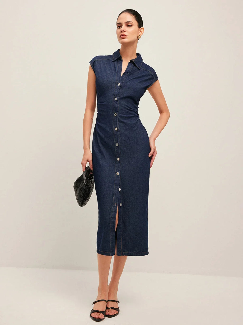 Women’s sleeveless dark blue denim midi dress with button-down front and classic collar, perfect for casual summer wear.