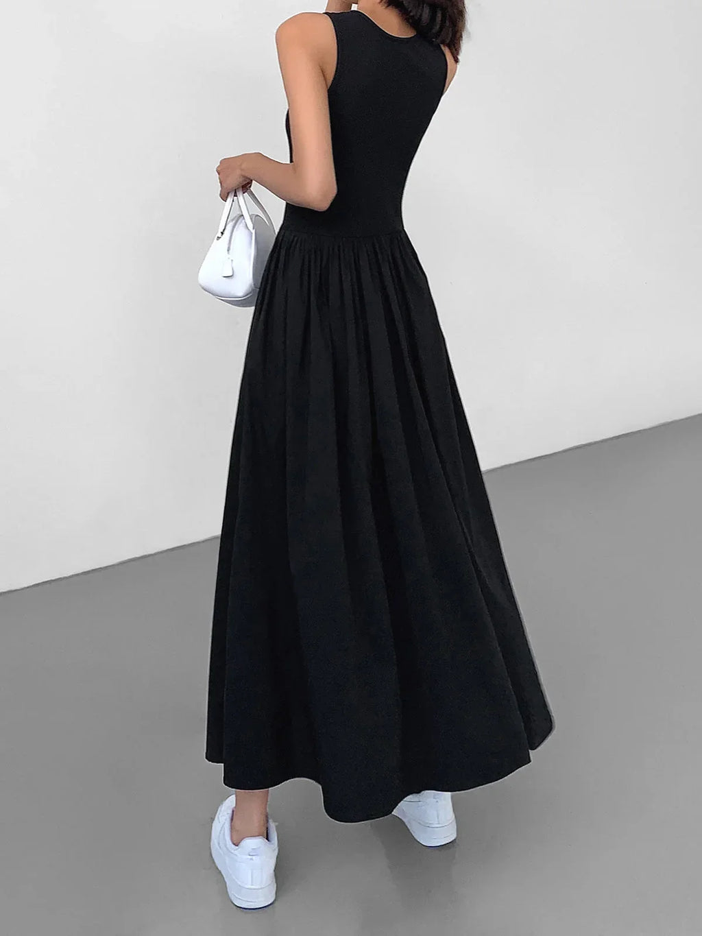 Sleeveless midi dress in soft jersey fabric, featuring a flowing skirt and a comfortable fit for everyday wear.
