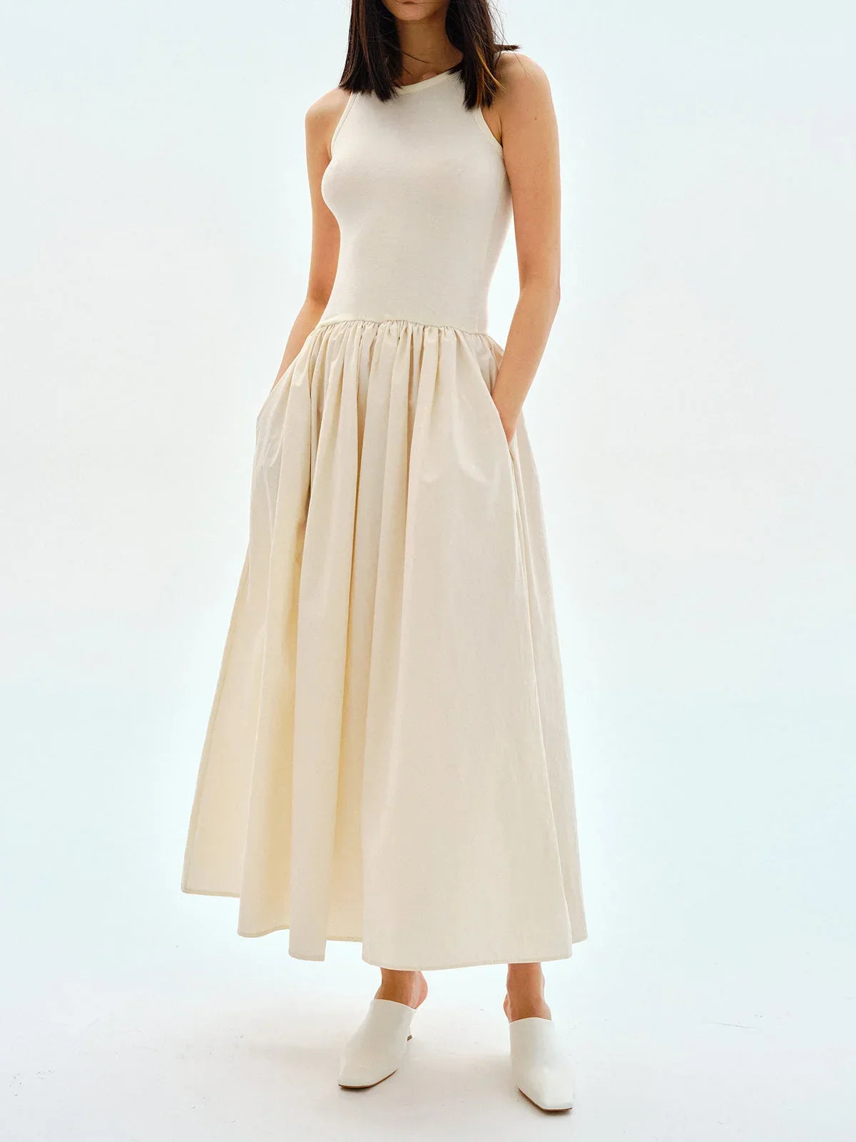 Apricot sleeveless midi dress in jersey fabric, featuring a flowing skirt for a comfortable and stylish look.