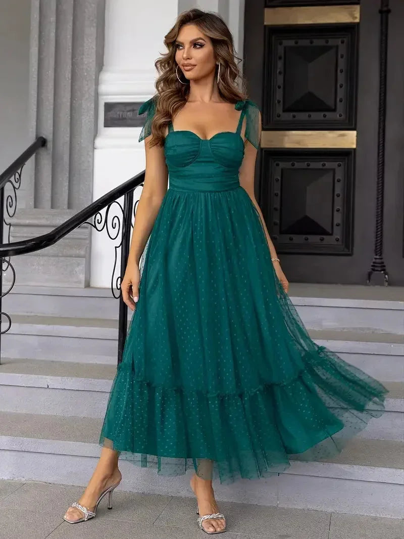 Green sleeveless midi dress featuring polka dot mesh and bow straps, made from lightweight fabric for a relaxed fit.