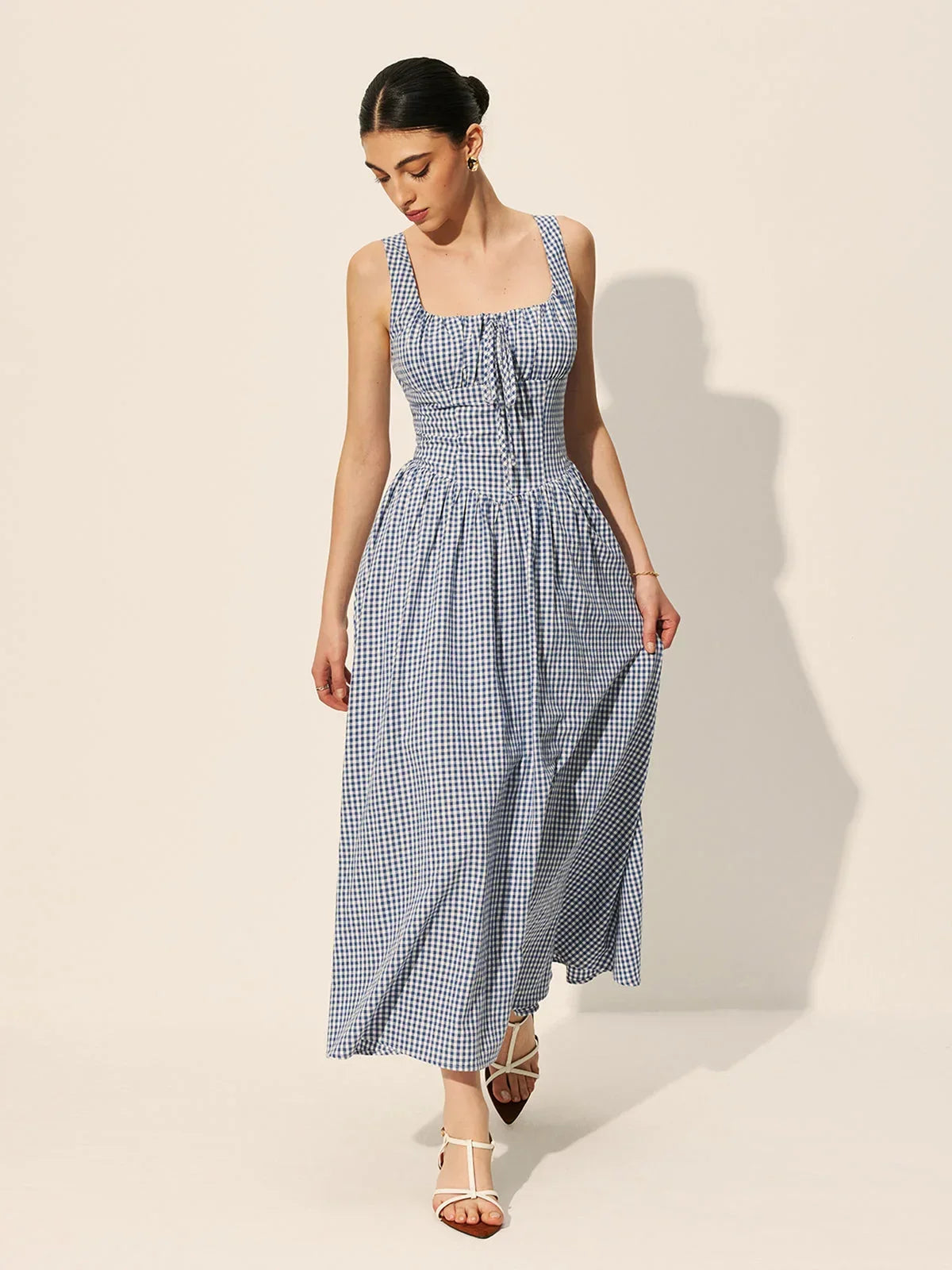 Women's sleeveless navy gingham midi dress featuring a square neckline and lightweight cotton fabric for breathability and…