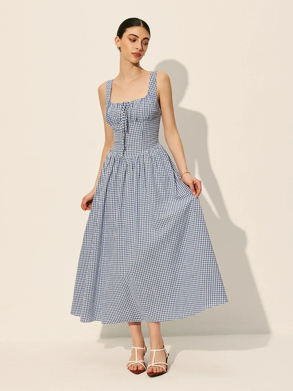 Women’s sleeveless navy gingham midi dress featuring a square neckline and soft cotton blend fabric for comfort and style.