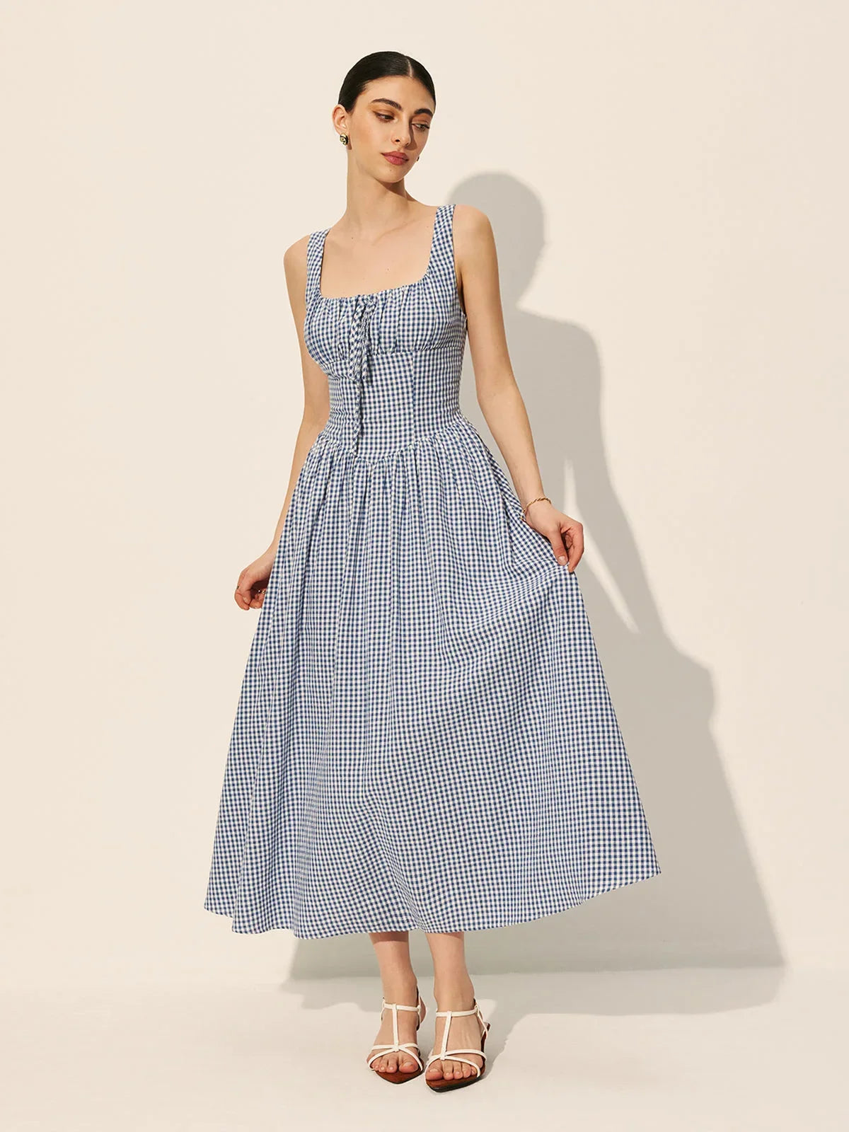 Women’s sleeveless navy gingham midi dress featuring a square neckline and soft cotton blend fabric for comfort and style.