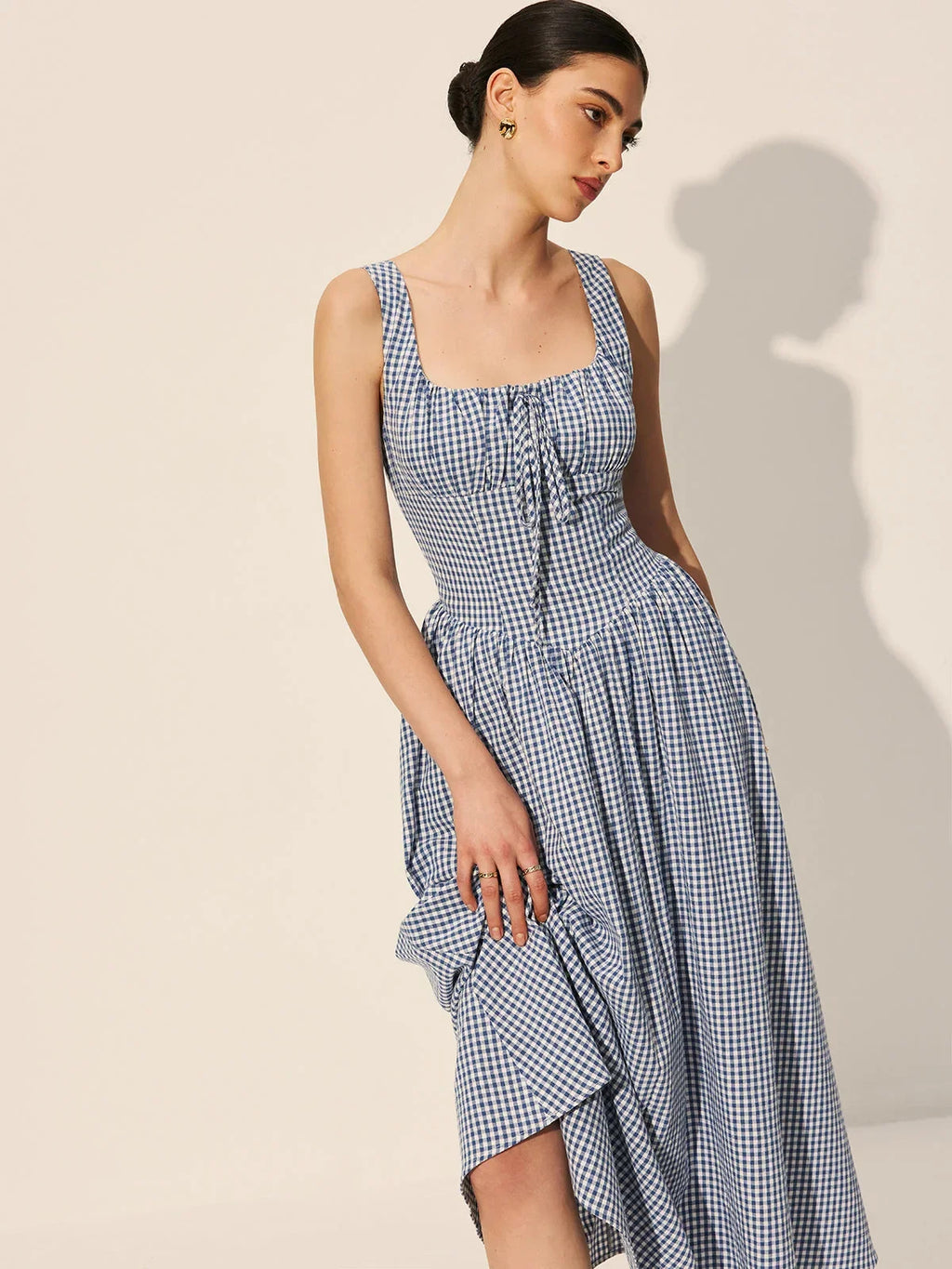 Women’s sleeveless navy gingham midi dress featuring a square neckline and lightweight cotton blend for comfort and…