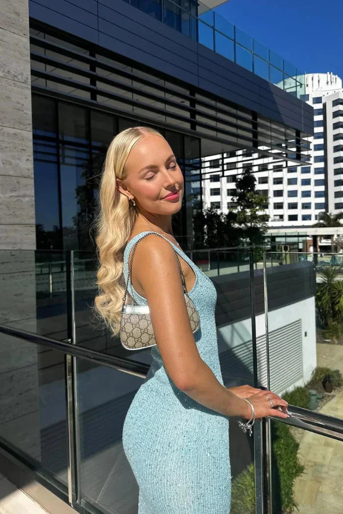 Women’s sleeveless fitted maxi dress in shimmering fabric, featuring a form-hugging design and elegant floor-length…