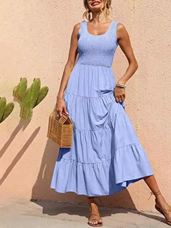 Light blue sleeveless maxi dress with a smocked bodice and tiered skirt, made from soft, breathable fabric for comfort.
