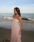 Pink strapless maxi dress with flowing ruffle details, made from lightweight fabric for a comfortable fit and elegant…
