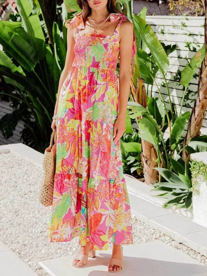 Red women's sleeveless maxi dress with tie straps, featuring a vibrant tropical print and lightweight fabric for comfort.